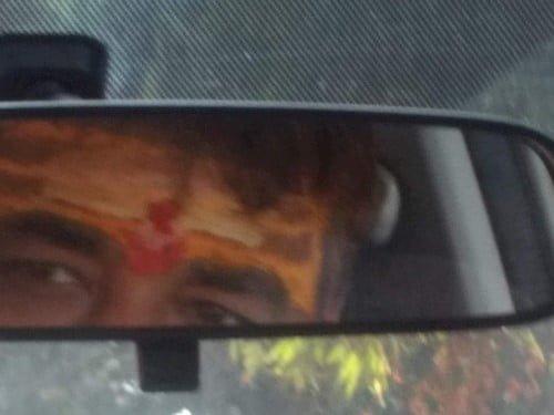 On the way back while driving the car, Chandrabhall is having a glance in the back mirror with Chandan & red Tika on his forehead